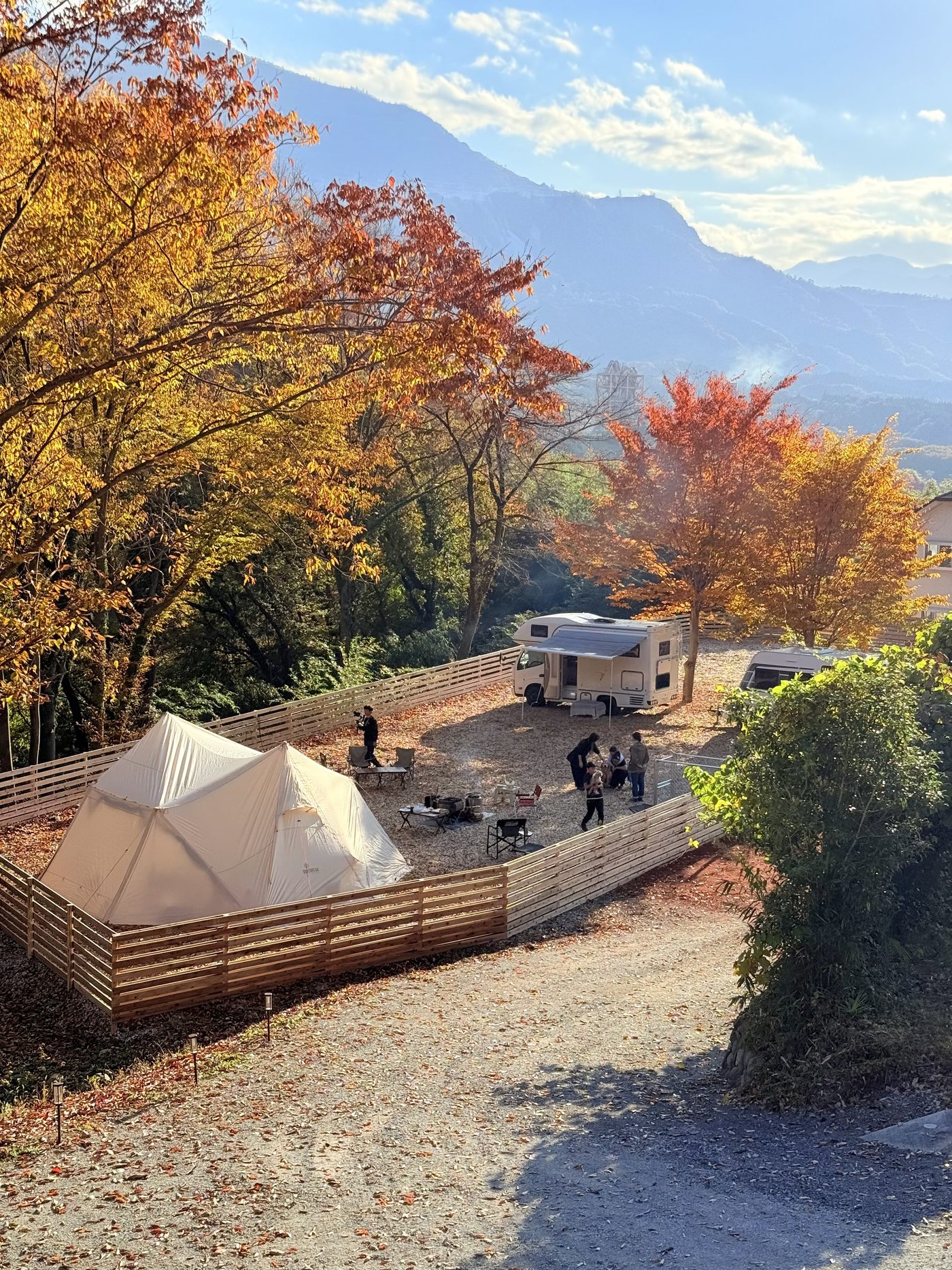 秋深まる紅葉のレイビレッジ。ウッドフェンスに囲まれたサイトとテント、武甲山の山並み